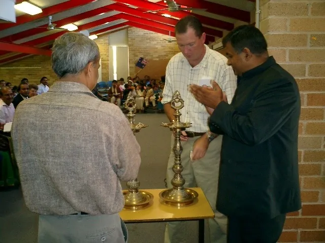 Guests gathered around ceremonial lamps at the Hindi school inauguration